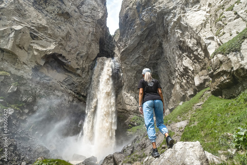 A girl at the Sultan-su waterfall surrounded by the Caucasus Mountains near Elbrus  Jily-su  Russia