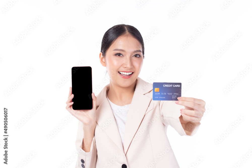 Portrait Asian happy young girl wearing pink suit happy smile and showing plastic credit card while holding mobile phone isolated on white background. Business online shopping concept. Portrait Asian happy young girl wearing pink suit happy smile and showing plastic credit card while holding mobile phone isolated on white background. Business online shopping concept.