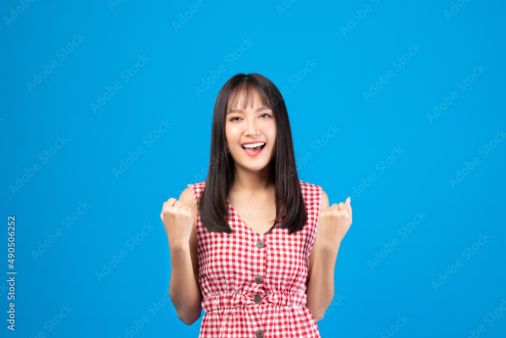 Image of feeling excited, shock, surprise, success and happy. Young asian woman standing on blue background. Female face expressions and emotions body language concept. Image of feeling excited, shock, surprise, success and happy. Young asian woman standing on blue background. Female face expressions and emotions body language concept.