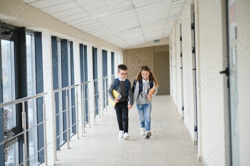 Cute pupils running down the hall at the elementary school