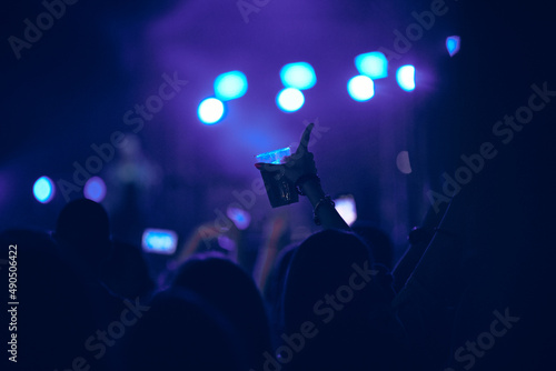 Person holding cold beer plastic cup on a music festival.