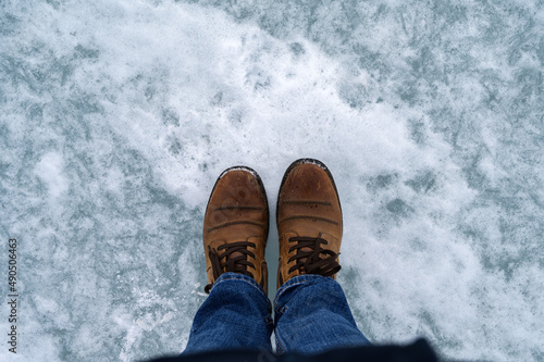Top view of boots on frozen sea surface.