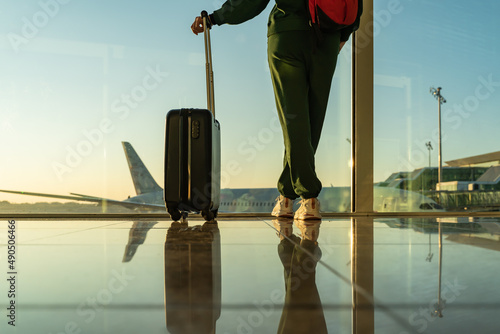 Obraz na płótnie woman with carry-on suitcase looking through the windows of the airport. w salonie