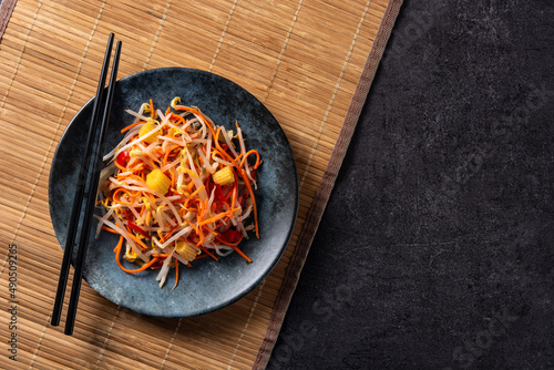 Healthy Chinese cabbage salad in plate on black background. Top view. Copy space photo