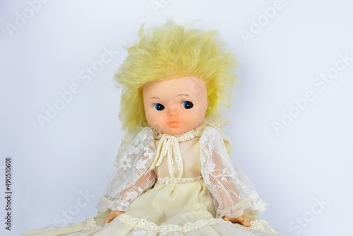 Vintage doll with yellow hair in lace dress on white background