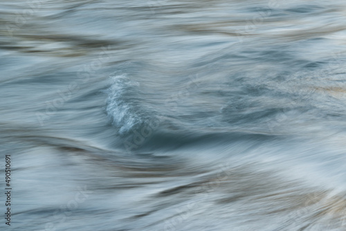 Silky water surface detail from rapid mountain stream in long exposure - abstract landscape