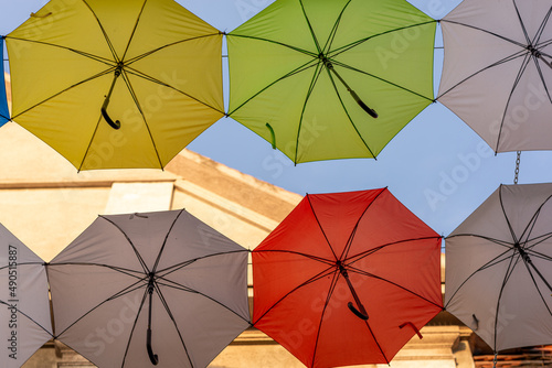Kolorowe parasolki rozwieszone nad ulic   prowadz  c   do Pszczy  skiego rynku. Fragment elewacji.
