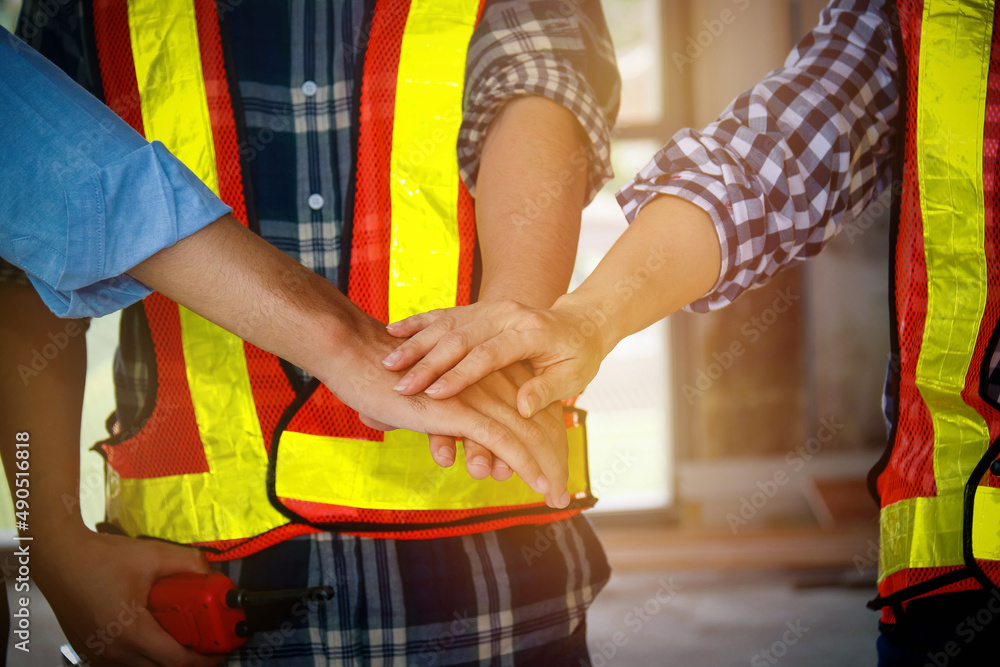 Obraz premium Workers shake hands for success : Group of workers working together as a team working on a construction site.