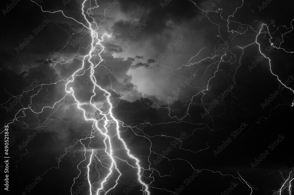 Thunder, lightnings and rain during summer storm in black and white.