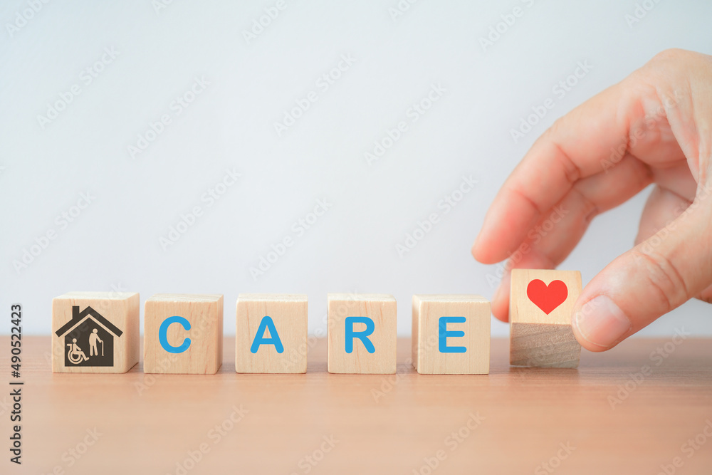 © Ratana21 - hand holding red heart icon on wood cube , care word and house with elderly and disability person icon inside for home care for aging people, nursing house concept © Ratana21 - hand holding red heart icon on wood cube , care word and house with elderly and disability person icon inside for home care for aging people, nursing house concept