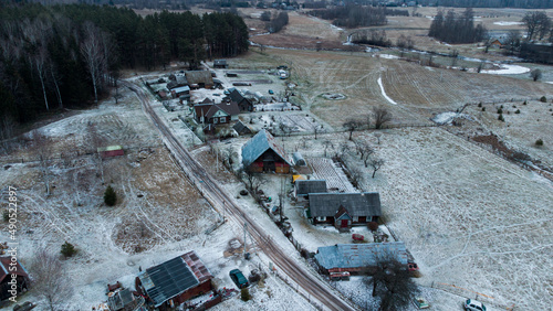 Aerial drone view. Small village around forest and fields. Winter time.