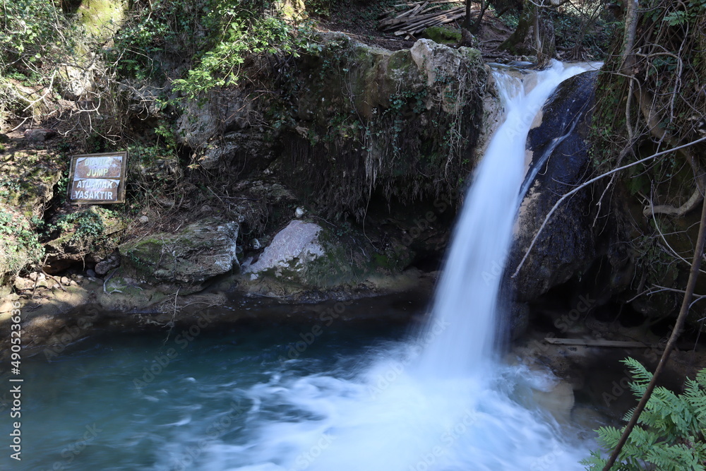 Naklejka premium small waterfall called Turgut Falls, water falling into pond, hiking area in Marmaris, Turkey