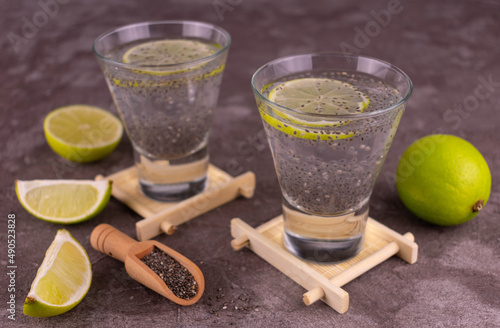 Water with chia seeds and lime on a gray background.	