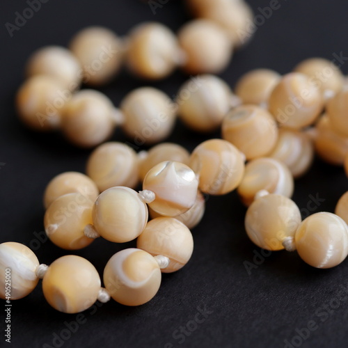 Mother of pearl nacre beads on black background.