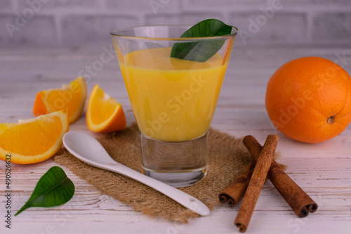 Orange cream mousse and juicy oranges with cinnamon on a light background	