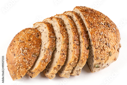 Round bread made of whole wheat flour with pumpkin, sesame, flax and sunflower seeds cut into pieces on a white isolated background. Bread without yeast, with sourdough. Proper nutrition.