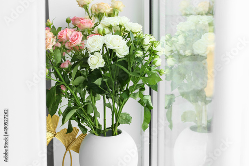 Vase with beautiful roses near window  closeup