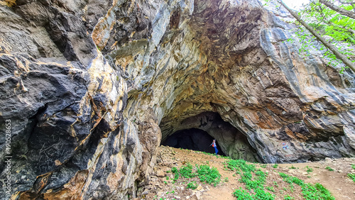 Woman at the entrance of the Drachenhoehle (Dragon Cave) in Pernegg an der Mur in Styria, Austria. Cave near mount Rothelstein in Mixnitz in the Grazer Bergland. Grotto, Europe. Hiking trail.
