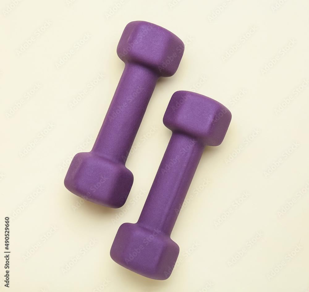 Stylish dumbbells on yellow background Stylish dumbbells on yellow background