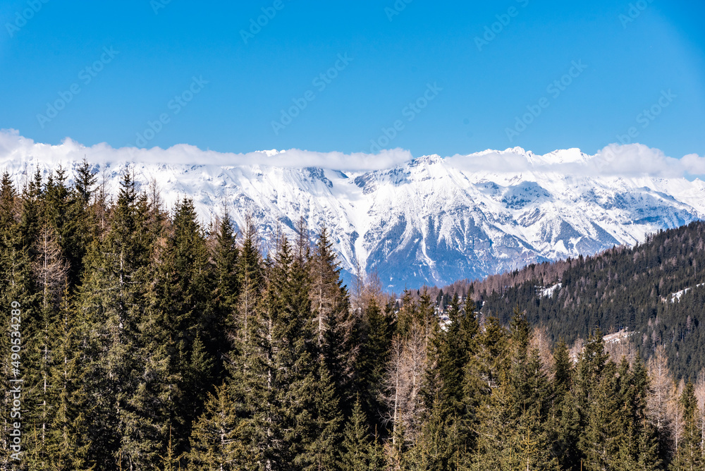 Wald und Berge mit Schnee, Blick vom Stubaital auf die Nordkette bei blauem Himmel