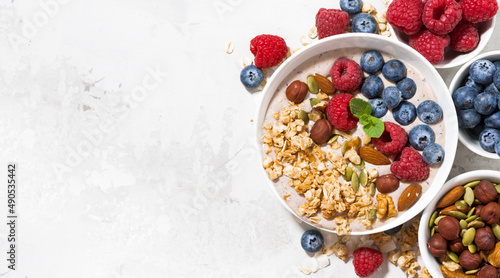 muesli with yogurt and berries for breakfast on white background, top view