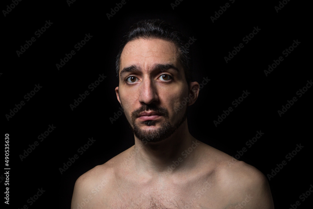 Sad expression. Male portrait on a black background. Desperate state