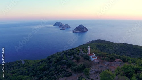 Aerial wide angle panning shot of the Gelidonya Lighthouse and five small Islands after sunset