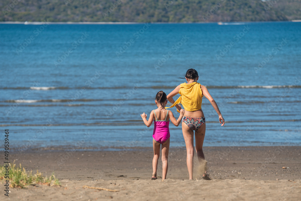 Two girls running to the beach on a beautiful summer day. Two girls running to the beach on a beautiful summer day.
