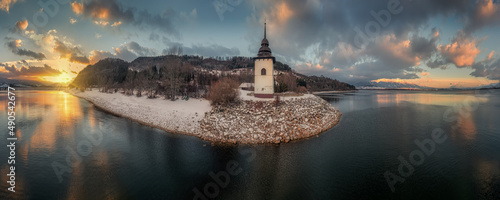 sunset on the coast of the Liptovska Mara dam with the tower of the old church photo