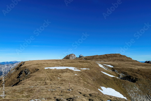 Hiking trail leading to mount Eisenerzer Reichenstein in Styria, Austria, Europe. Austrian Alps. Bare mountain ridges of Ennstal Alps with view on the Reichensteinhuette. Summit cross on the peak photo