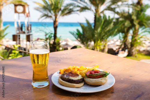 Delicious craft hamburger on a wooden plate in luxury hotel terrace with a sea view in summer time in Croatia