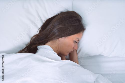 Depressed woman lying in the bed. Woman filling bad and suffering from depression
