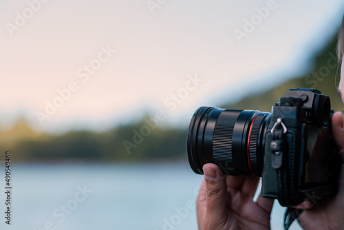 Hands holding a camera taking a photograph. Lesson class course learning photography.