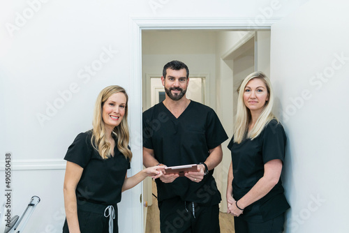 Konstfotografi A male physician doctor at a medical spa and wellness clinic speaking to two fem