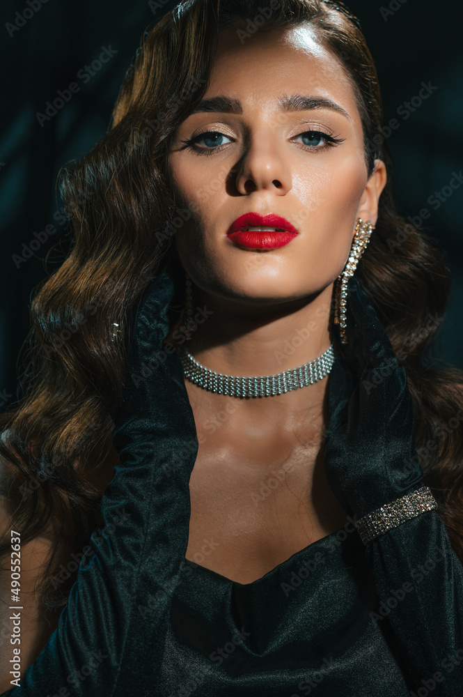 Portrait of young woman in Hollywood retro noir style. A beautiful brunette girl with a hairstyle and makeup with jewelry in classic vintage look Portrait of young woman in Hollywood retro noir style. A beautiful brunette girl with a hairstyle and makeup with jewelry in classic vintage look