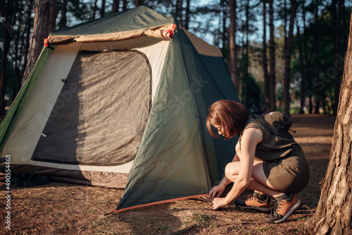 Foto An Asian woman is pitching a tent in the pine tree forest at Pang Oung, Mae Hong Son province, Thailand