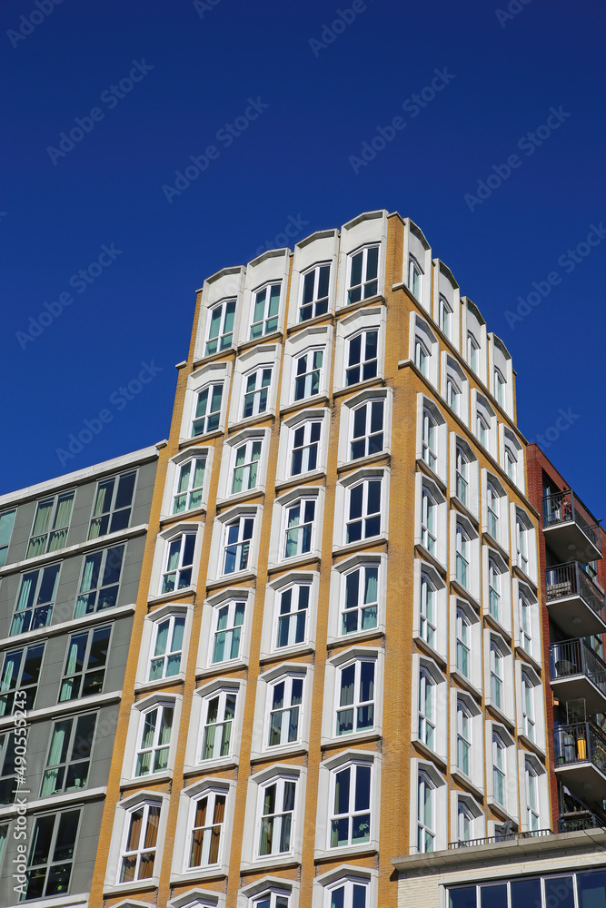 Nijmegen (Plein 1944), Netherlands - February 27. 2022: Low angle view on 3 buildings in different architectural styles contrasting with deep blue cloudless sky