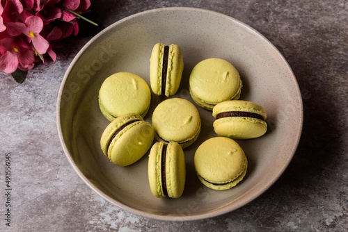 Macarons with black chocolate on a plate