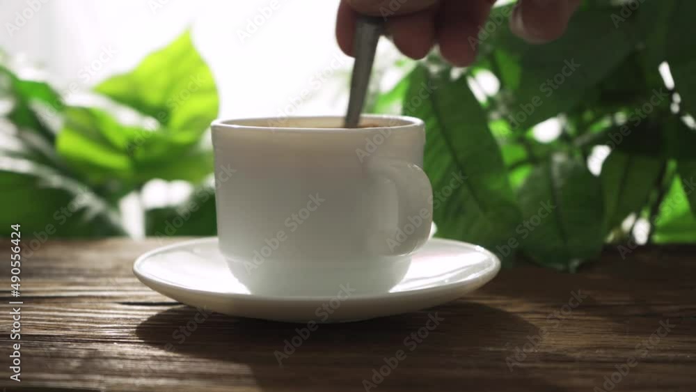 Hand, stirring sugar in a mug of tea. Hand, stirring sugar in a mug of tea.