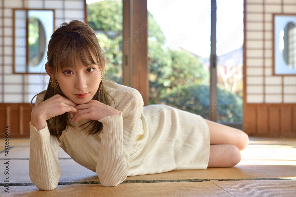 畳の上に横たわり頬杖をつく白いワンピースを着た若い女性 畳の上に横たわり頬杖をつく白いワンピースを着た若い女性