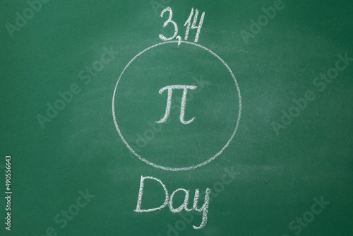 The Greek letter Pi is drawn in chalk on a green school blackboard in a circle in honor of the international day of March 14