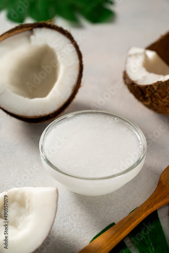 Coconut oil with fresh nut pieces. Healthy food. Bright background.
