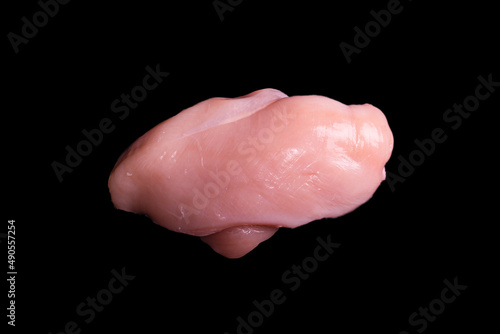 Raw chicken fillet isolated on a black background.