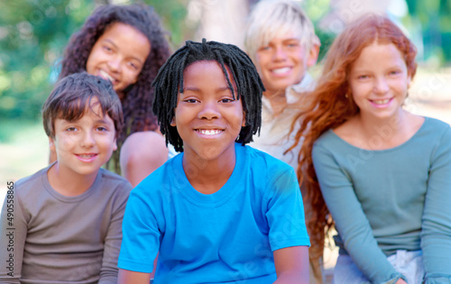 They are our future. A group of children smiling at the camera in the outdoors.