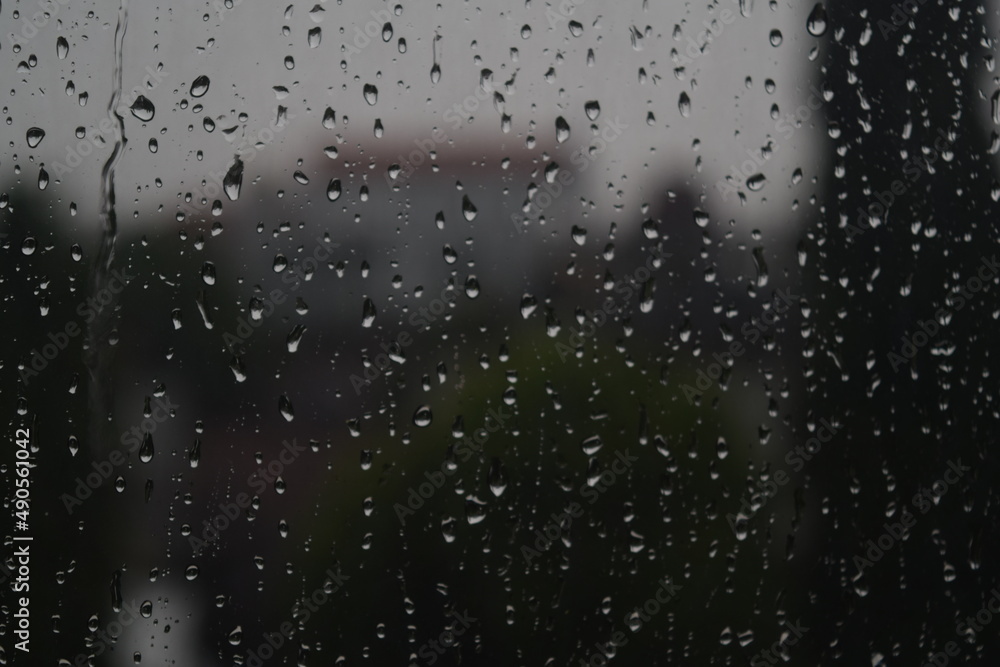 rain water wets the glass windows of the house