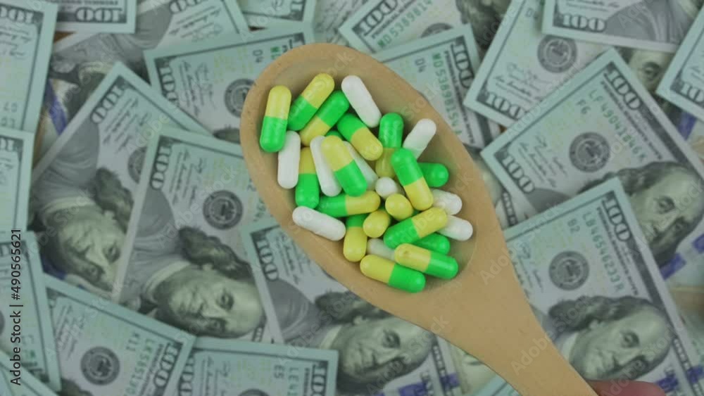Wooden spoon is full of multi colored medical capsules in male hand. Pharmaceutical industry and medicine business. Wooden spoon is full of multi colored medical capsules in male hand. Pharmaceutical industry and medicine business.