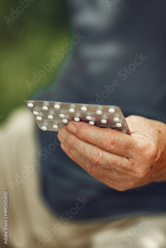 Portrait of helderly man holding pills
