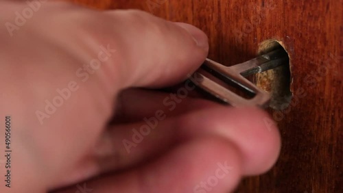The Old ancient key to open the cabinet. Metal old antique key. Old dilapidated door to open with a metal antique key.