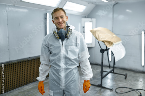 Satisfied tired sweaty repairman after painting car