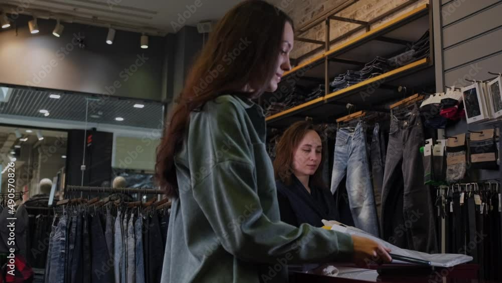 The girl pays for purchases through the terminal The girl pays for purchases through the terminal